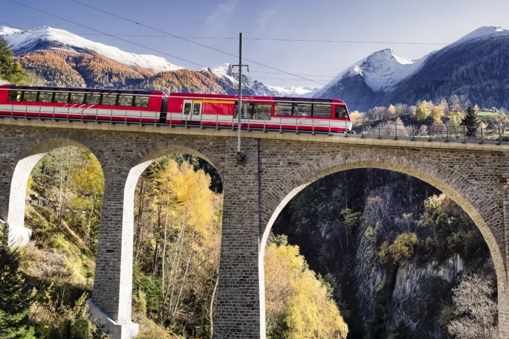 Swiss train passing over stone bridge